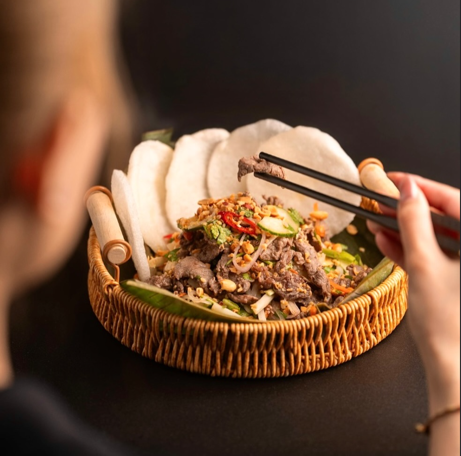 Elegant bowl of Vietnamese pho with herbs, lime, and thin sliced beef