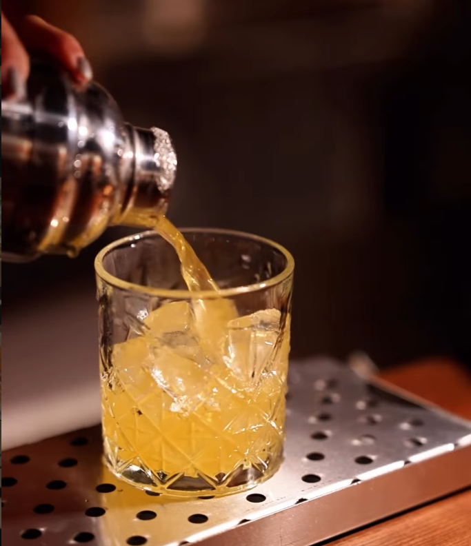 Luxury restaurant cocktails with citrus garnish on a dark bar counter
